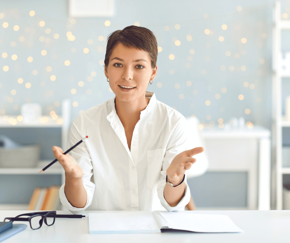 Speak English Without Fear A confident young woman speaking and gesturing during an English practice session at a desk, symbolizing fearless communication.