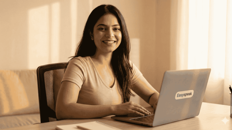 A wide, professional photograph of a young South Asian woman smiling confidently as she presents during a live online session from a beautifully lit home office. On the right side of the frame, large, crisp typography in maroon and golden-yellow reads, "TAKE THE NEXT STEP." Beneath it, a call-to-action reads, "Join the Live Online Academy." A prominent golden button below the text reads "Enroll Now," and a neat wooden block featuring the Easyspeak logo sits on the desk in the foreground.